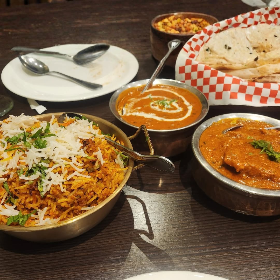 A full table of biryani, curries and naan
